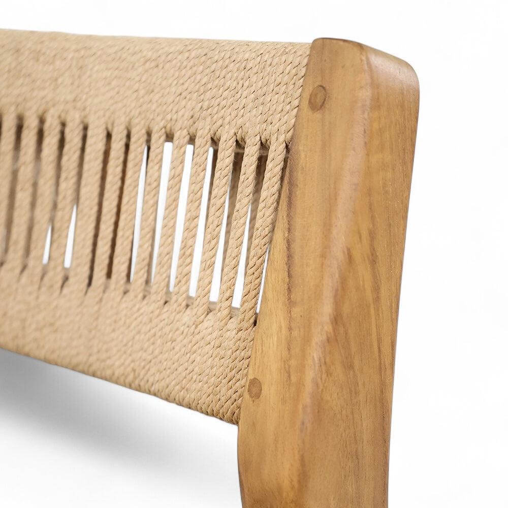Close-up of a handwoven loom seat on a teak dining chair, showcasing natural fibers and wood grain detail.