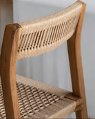 Close-up of a teak dining chair showcasing the handwoven natural loom backrest and seat detailing.