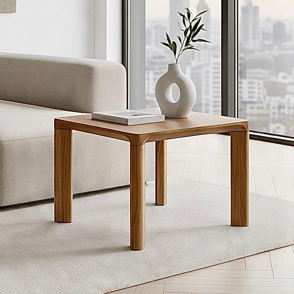 Wooden side table with a white vase and book in a modern living room.