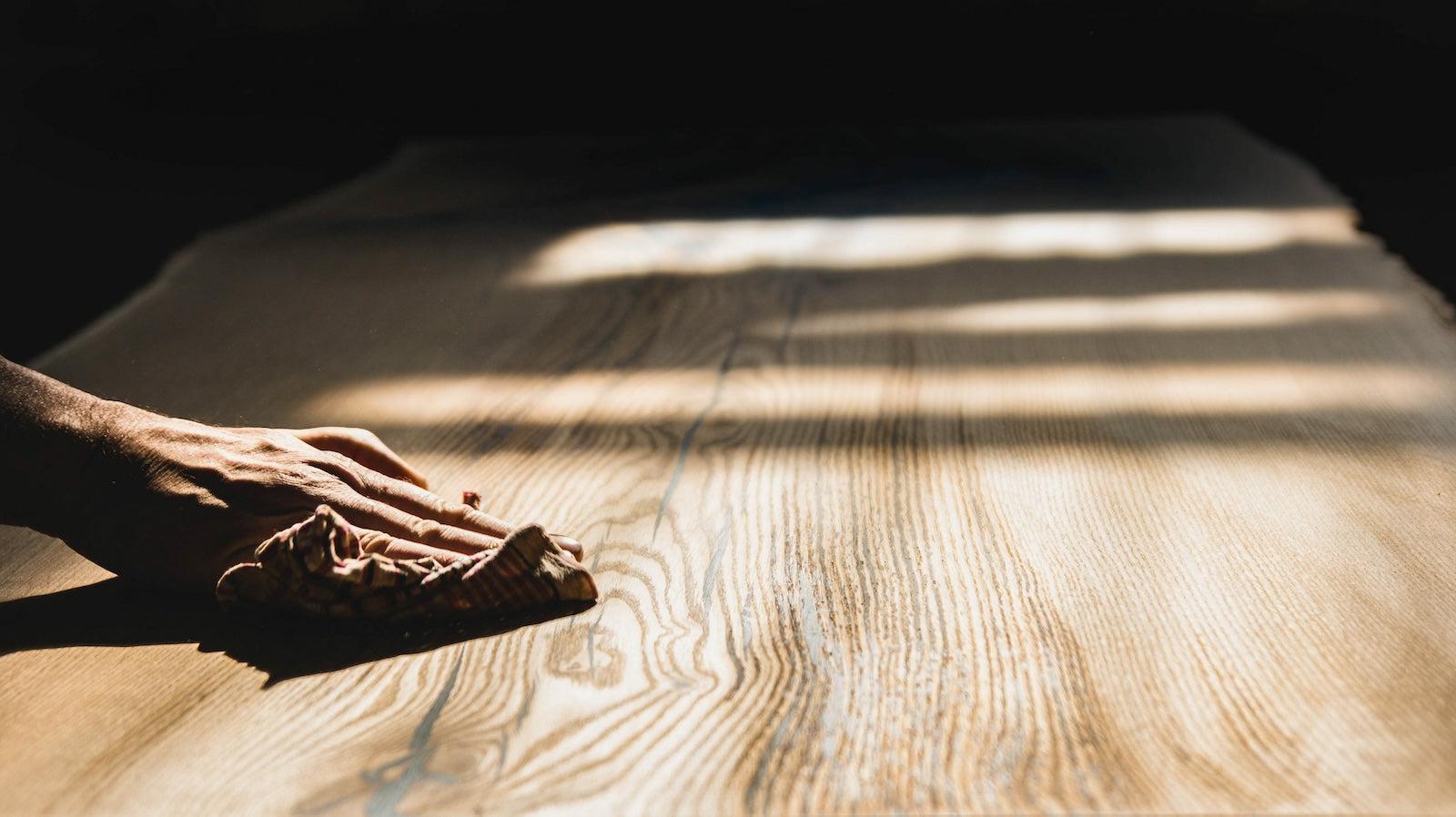 A  craftsman polishes a teak dining table 