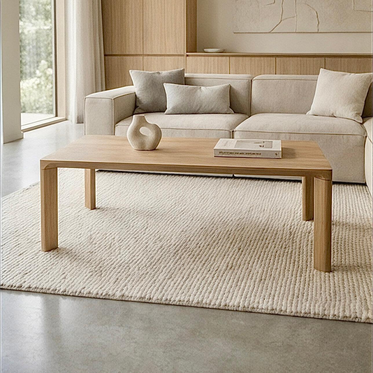 Modern living room with a beige sofa, wooden coffee table, and decorative items.