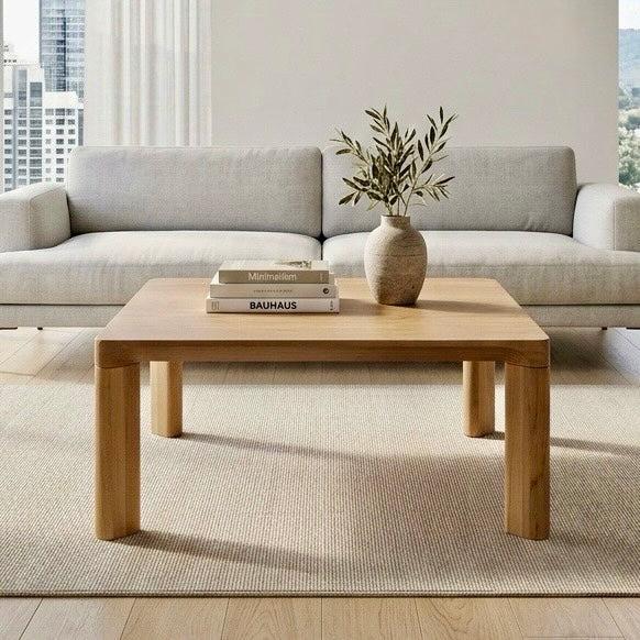 Wooden coffee table with a vase and books in a living room setting