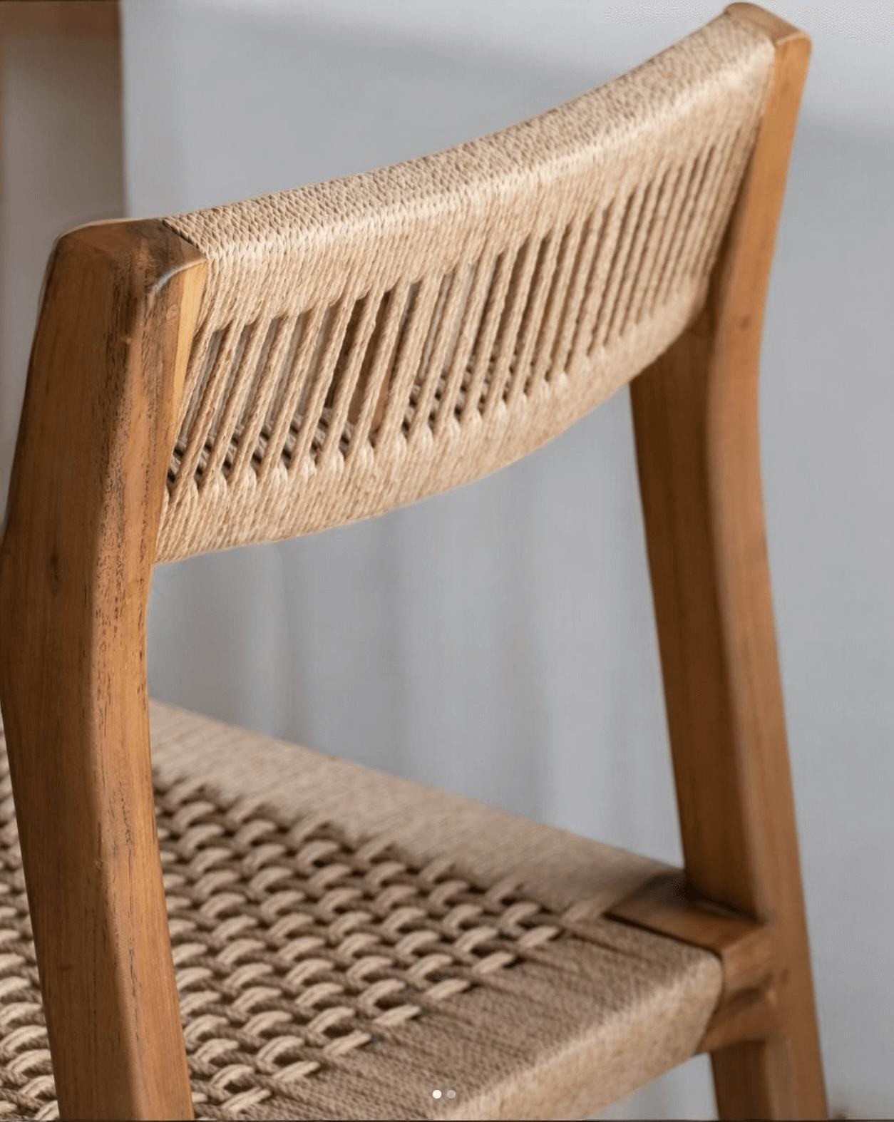 Close-up of a teak dining chair showcasing the handwoven natural loom backrest and seat detailing.