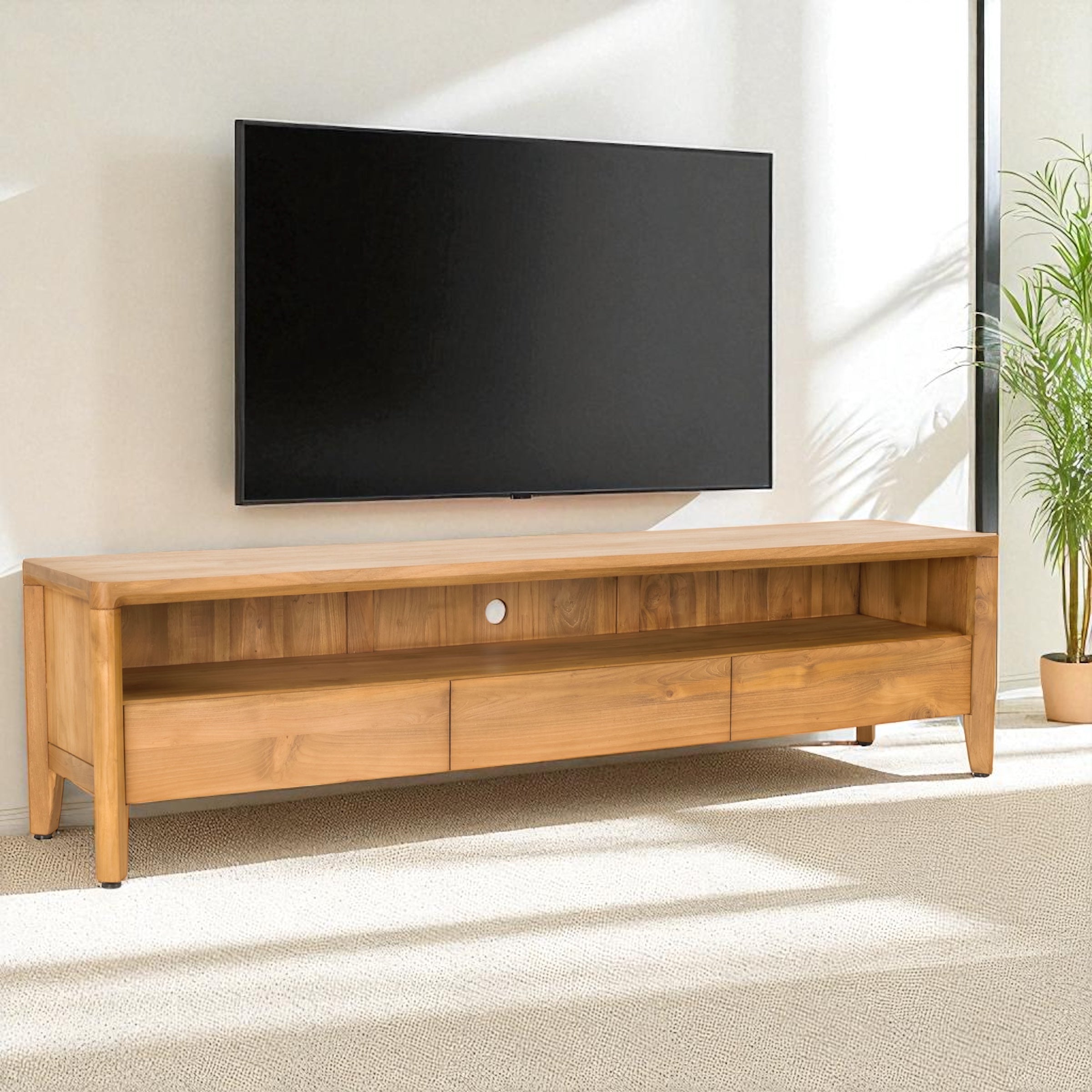 Wooden TV stand with a television mounted on a wall in a room with a plant.