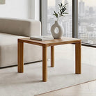 Wooden side table with a white vase and book in a modern living room.